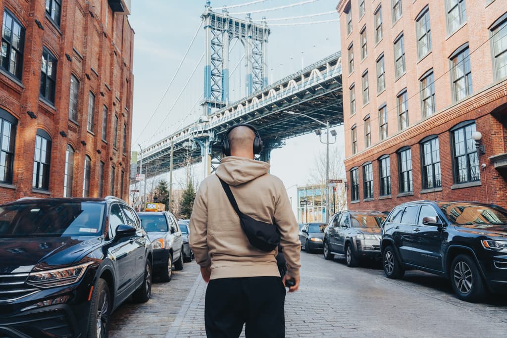 Mann med hettegenser og crossbody-veske i urban setting
